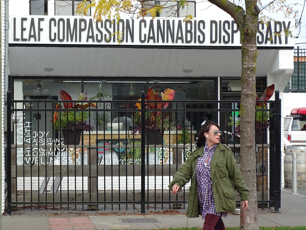 Leaf Compassion Cannabis Dispensary storefront with a woman walking past